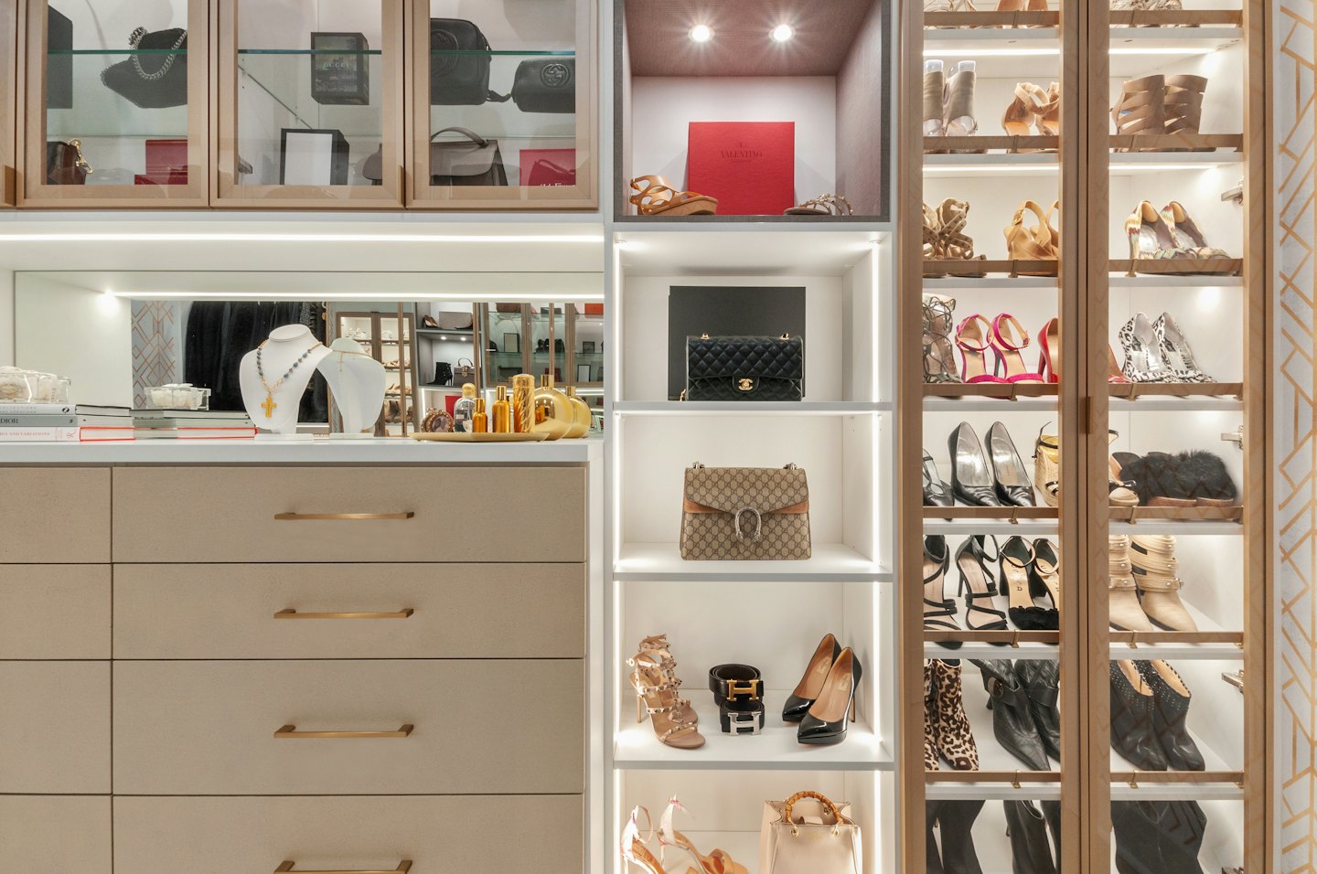 Luxury handbags, shoes, and jewelry displayed in an organized closet.