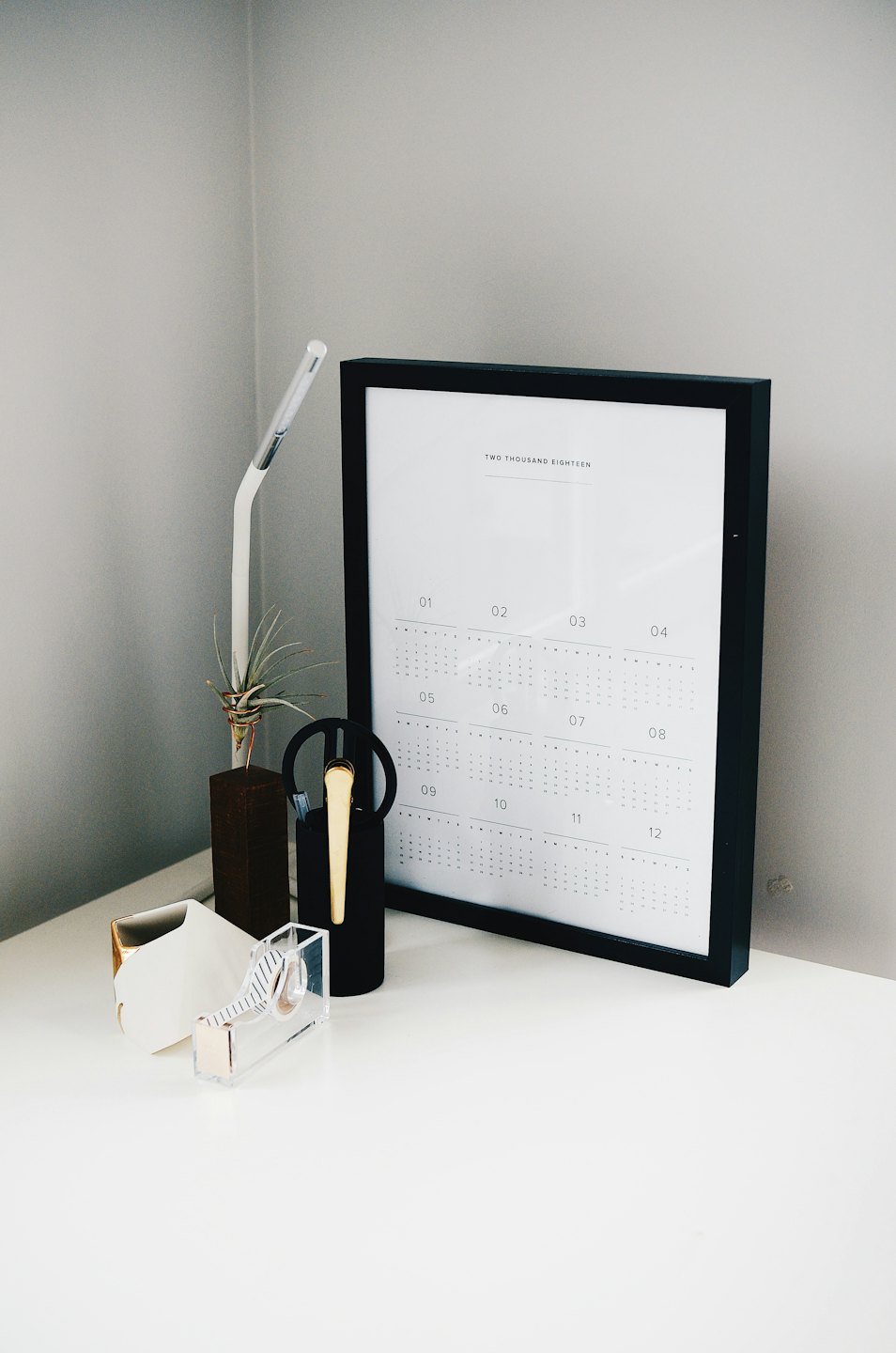 Desk calendar and office supplies on a clean white desk.