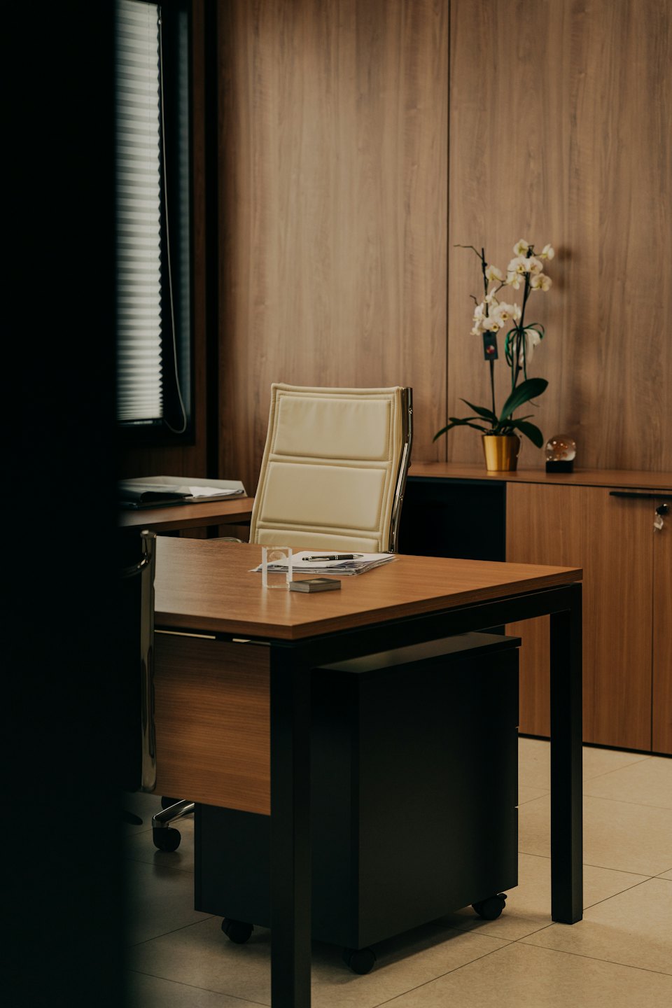 Modern office desk and chair with a white orchid.